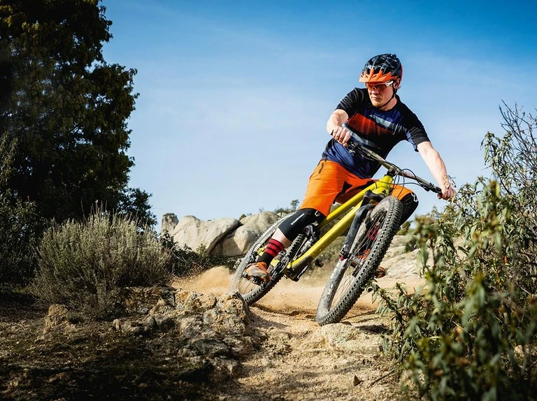 Rider braking into a loose corner on a mountain trail
